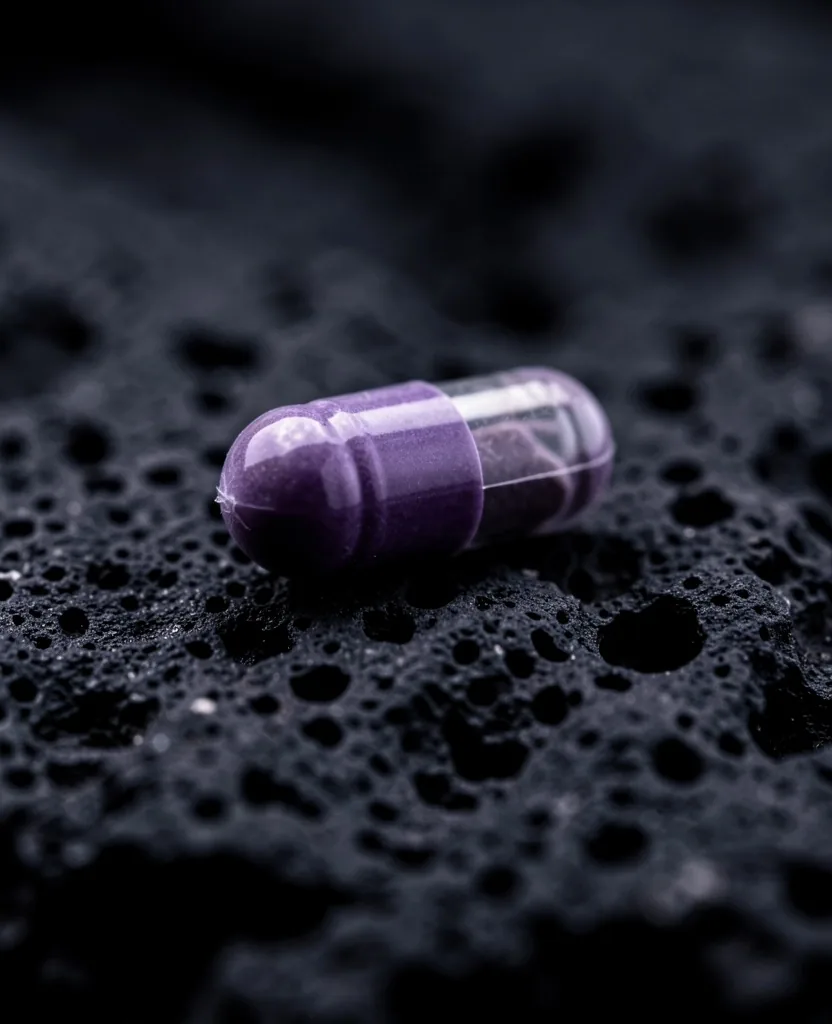 Natural supplement capsule on dark stone surface